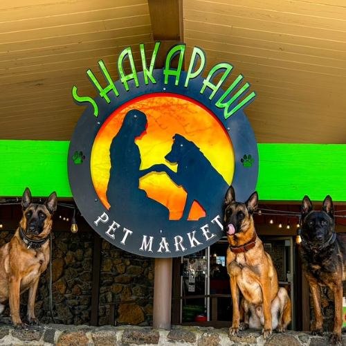 ShakaPaw logo with three dogs sitting in the front of it.